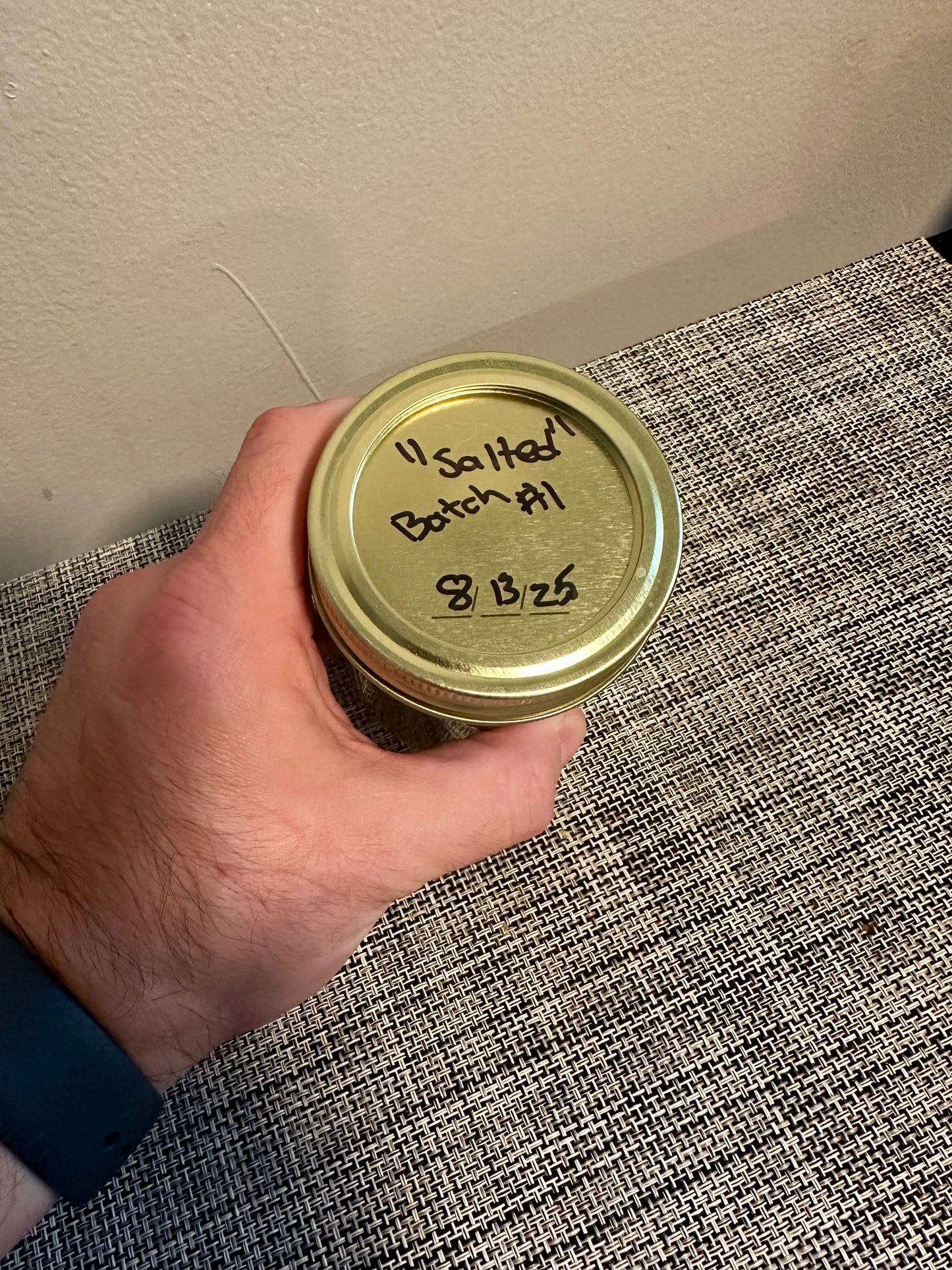 Labeled lid of Small Batch Salted Caramel Sauce jar marked 'Salted Batch #1' with date, showcasing handcrafted gourmet caramel.