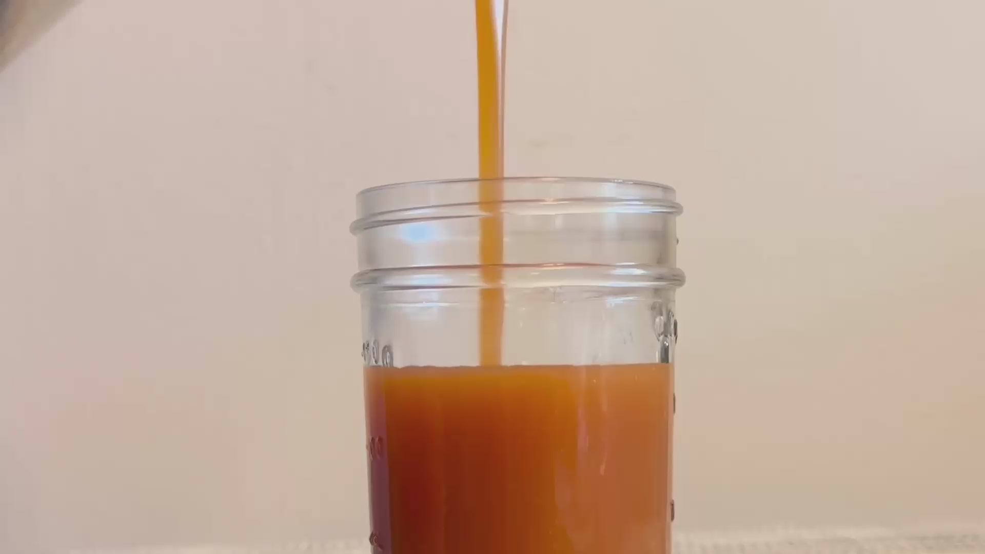 Apple Cinnamon Caramel – Fall Limited Edition being poured into a glass jar, highlighting its golden hue and thick, buttery consistency.